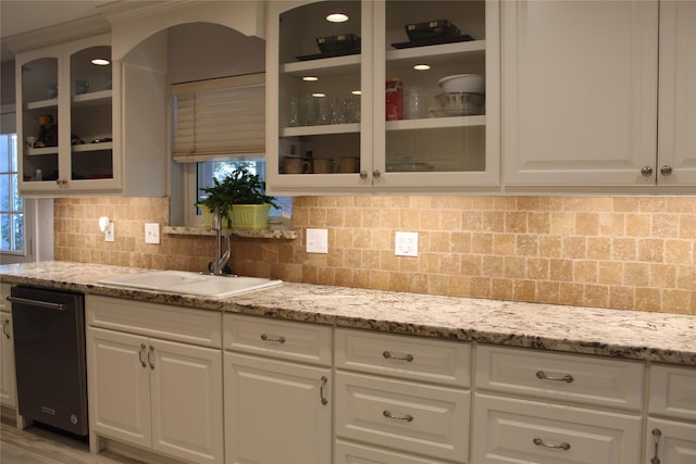 638 Andover St, Spring, TX 77373 - kitchen with light stone counters, backsplash, glass insert cabinets, and dishwashing machine