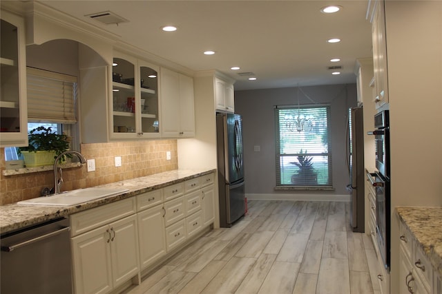 638 Andover St, Spring, TX 77373 - kitchen featuring appliances with stainless steel finishes, recessed lighting, white cabinets, tasteful backsplash, and glass insert cabinets