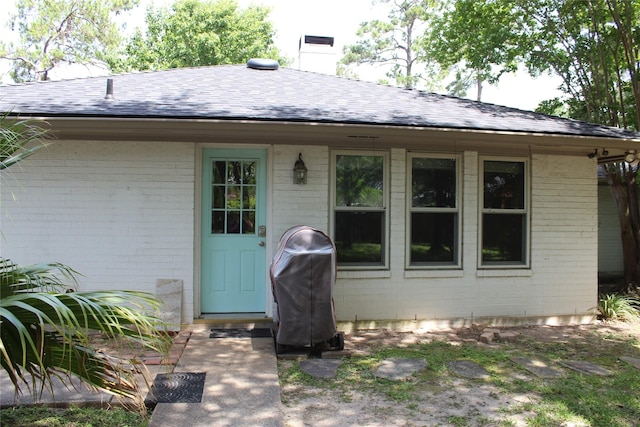 638 Andover St, Spring, TX 77373 - view of exterior entry featuring brick siding, roof with shingles, and a chimney
