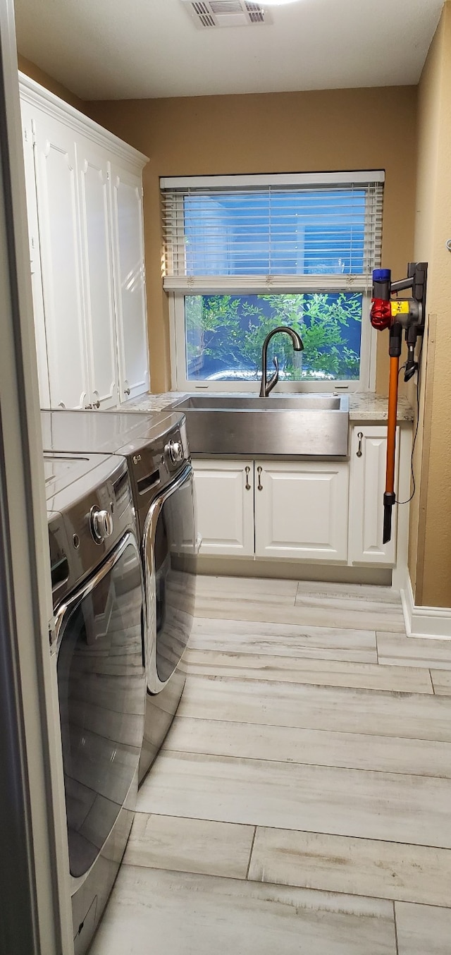 638 Andover St, Spring, TX 77373 - laundry area featuring cabinet space, washer and clothes dryer, and light wood finished floors