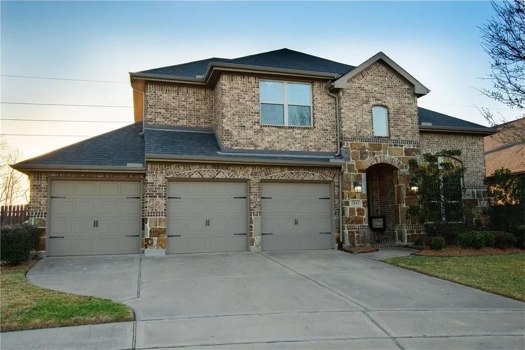 2842 Walnut Crest Dr, Katy, TX 77494 - french country home featuring driveway, roof with shingles, brick siding, and a garage