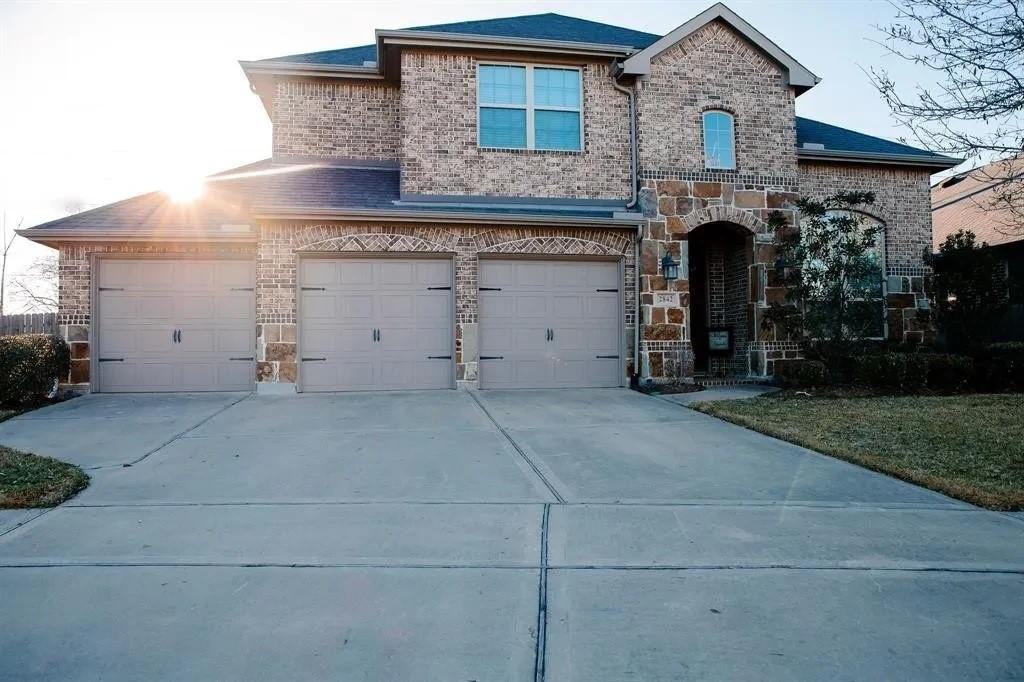 2842 Walnut Crest Dr, Katy, TX 77494 - french country home with brick siding, driveway, stone siding, and an attached garage