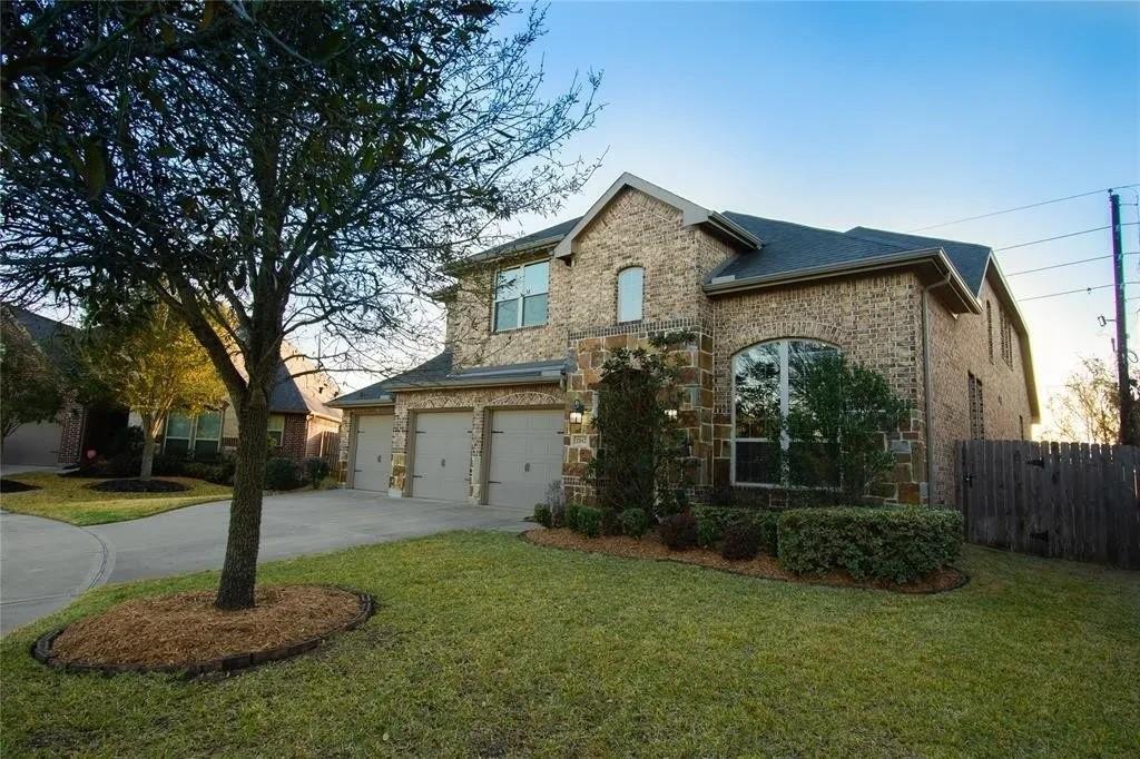 2842 Walnut Crest Dr, Katy, TX 77494 - french country style house featuring concrete driveway, an attached garage, stone siding, and brick siding