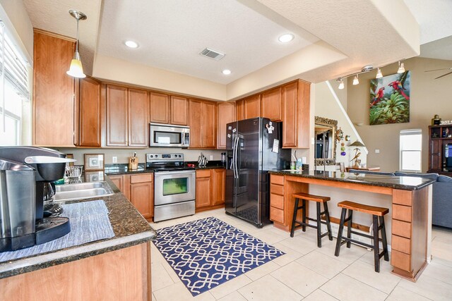 115 Mar Vista Ct, Surfside Beach, TX 77541 - kitchen with stainless steel appliances, a peninsula, a kitchen breakfast bar, light tile patterned flooring, and recessed lighting