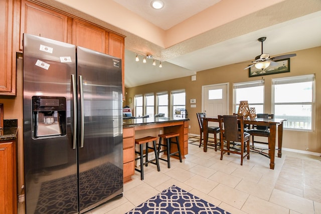 115 Mar Vista Ct, Surfside Beach, TX 77541 - kitchen with stainless steel fridge with ice dispenser, brown cabinetry, a peninsula, and ceiling fan