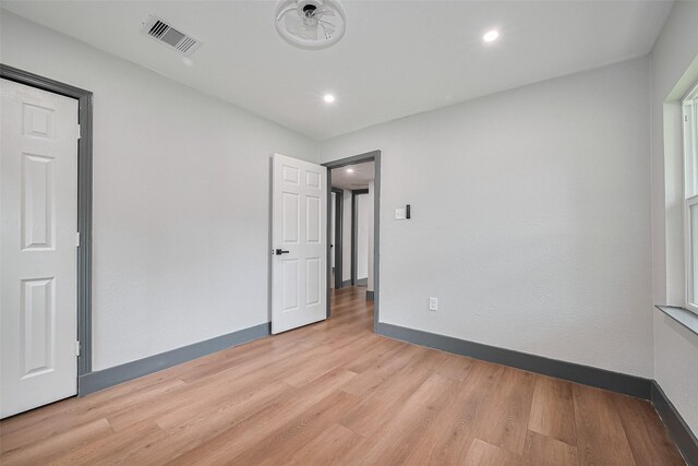 6058 Lyndhurst Dr, Houston, TX 77033 - unfurnished bedroom with light wood-style flooring, baseboards, and recessed lighting