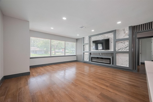 6058 Lyndhurst Dr, Houston, TX 77033 - unfurnished living room featuring baseboards, wood finished floors, a glass covered fireplace, and recessed lighting