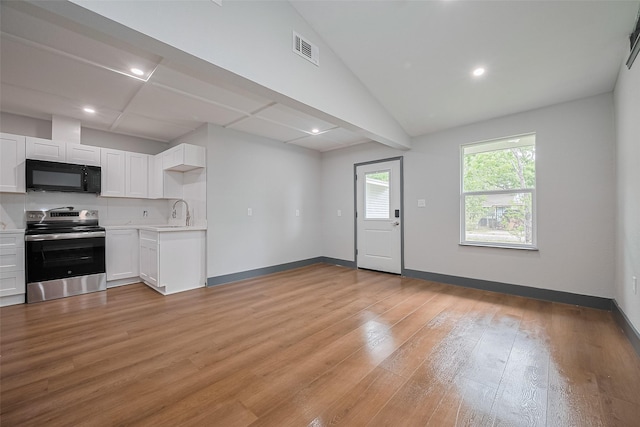 6058 Lyndhurst Dr, Houston, TX 77033 - unfurnished living room with light wood-type flooring, a sink, baseboards, recessed lighting, and lofted ceiling