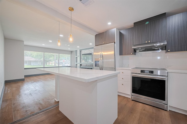 6058 Lyndhurst Dr, Houston, TX 77033 - kitchen featuring appliances with stainless steel finishes, under cabinet range hood, a kitchen island, wood finished floors, and recessed lighting