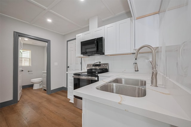 6058 Lyndhurst Dr, Houston, TX 77033 - kitchen featuring black microwave, electric stove, white cabinetry, recessed lighting, and wood finished floors