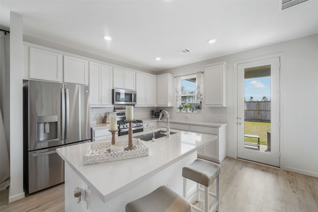 7134 Clearwater Cove Dr, Cypress, TX 77433 - kitchen featuring appliances with stainless steel finishes, a sink, decorative backsplash, light wood-style floors, and recessed lighting