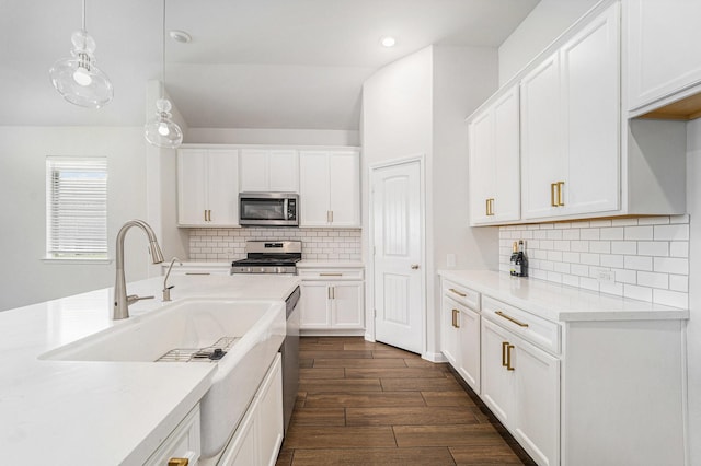 7714 Squall Ln, Baytown, TX 77523 - kitchen with stainless steel appliances, dark wood-style flooring, light countertops, white cabinetry, and recessed lighting