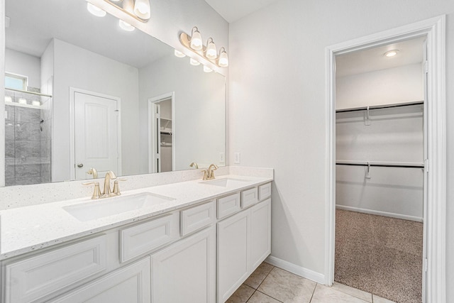 7714 Squall Ln, Baytown, TX 77523 - full bathroom featuring double vanity, a walk in closet, tile patterned floors, a tile shower, and baseboards