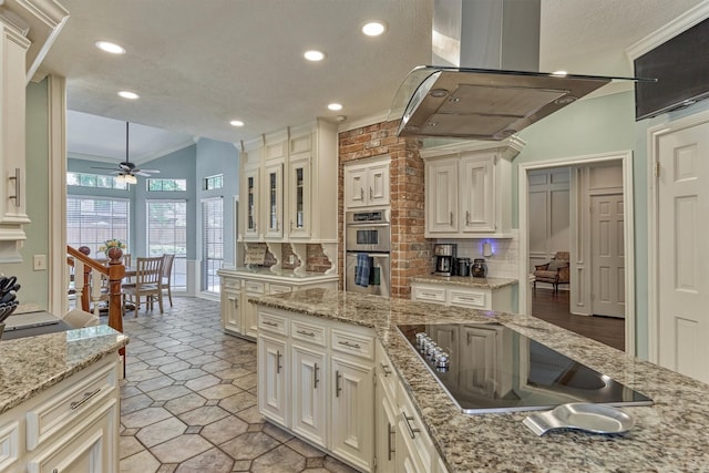 5211 Rothchilde Ct, Houston, TX 77069 - kitchen with island exhaust hood, black electric cooktop, ceiling fan, ornamental molding, and double oven