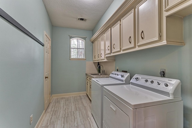 5211 Rothchilde Ct, Houston, TX 77069 - washroom featuring cabinet space, washer and clothes dryer, a textured ceiling, and baseboards