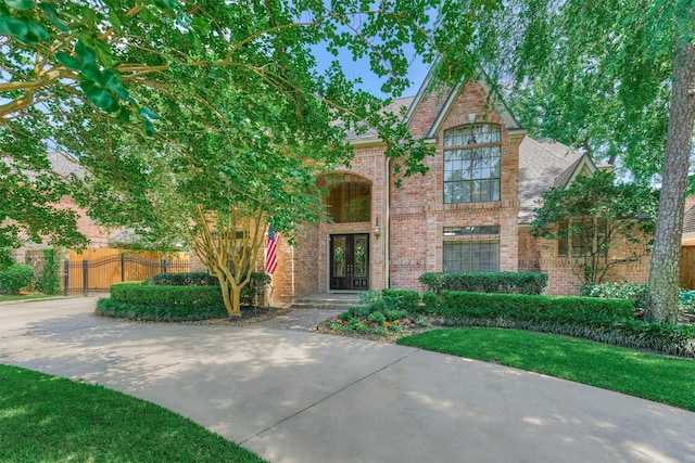 5211 Rothchilde Ct, Houston, TX 77069 - view of front facade with french doors, brick siding, and roof with shingles