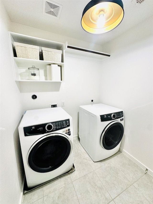 12531 Hilltop Mill Rd, Magnolia, TX 77354 - laundry area with washer and clothes dryer, light tile patterned flooring, and baseboards