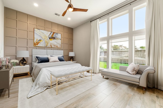 13909 Morgan Bay Dr, Pearland, TX 77584 - bedroom with light wood-style flooring, an accent wall, ceiling fan, and recessed lighting