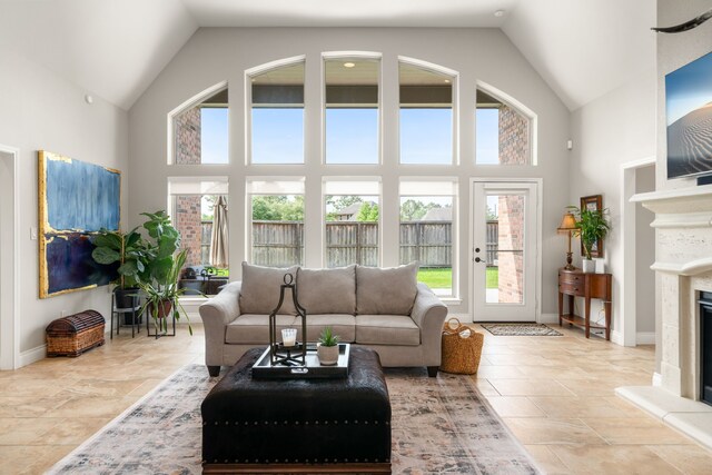 13909 Morgan Bay Dr, Pearland, TX 77584 - living room featuring high vaulted ceiling, a fireplace with raised hearth, and baseboards