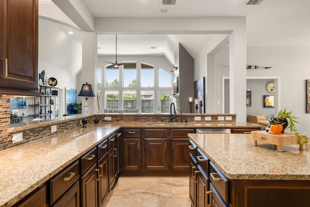 13909 Morgan Bay Dr, Pearland, TX 77584 - kitchen with a sink, light stone counters, tasteful backsplash, vaulted ceiling, and light marble finish flooring