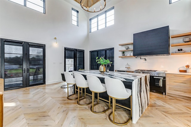 1030 Voight St, Houston, TX 77009 - kitchen featuring open shelves, high end stove, a towering ceiling, a chandelier, and a kitchen island
