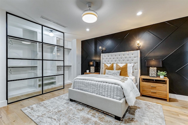 1030 Voight St, Houston, TX 77009 - bedroom featuring an accent wall and wood finished floors