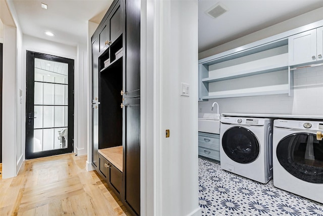 1030 Voight St, Houston, TX 77009 - laundry area with washer and clothes dryer, cabinet space, recessed lighting, and light wood-type flooring