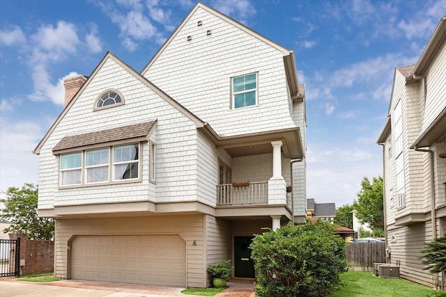 2409 Ralph St Unit A, Houston, TX 77006 - view of front of property with a balcony, an attached garage, a chimney, concrete driveway, and central air condition unit