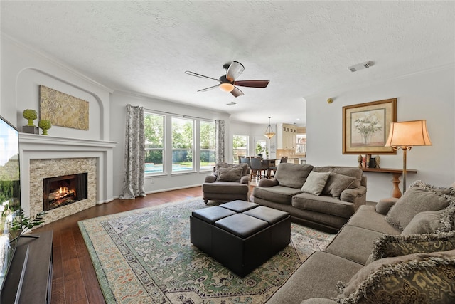 4019 Bellinger Way, Missouri City, TX 77459 - living room with a ceiling fan, hardwood / wood-style floors, a textured ceiling, ornamental molding, and a warm lit fireplace