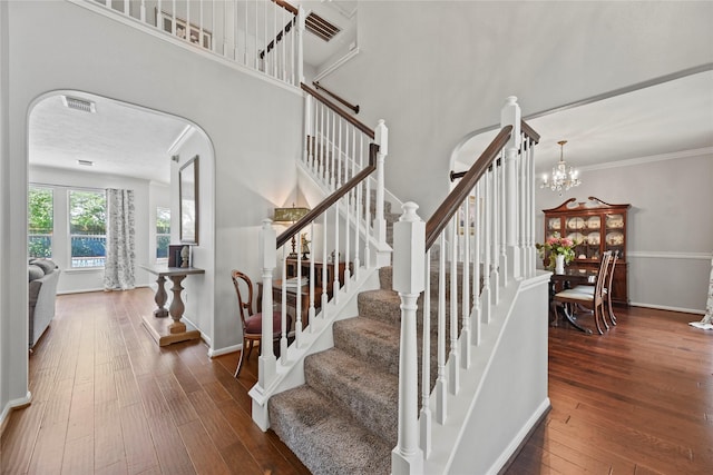4019 Bellinger Way, Missouri City, TX 77459 - stairs featuring hardwood / wood-style flooring, arched walkways, a chandelier, and baseboards