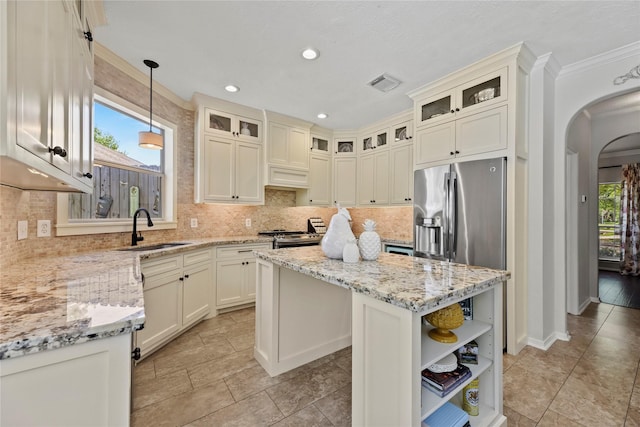 4019 Bellinger Way, Missouri City, TX 77459 - kitchen featuring a sink, arched walkways, a center island, open shelves, and decorative backsplash