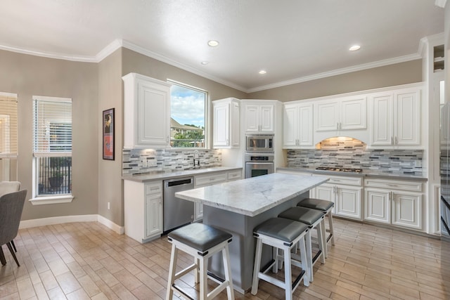 13207 Regency Oak Ln, Cypress, TX 77429 - kitchen featuring stainless steel appliances, a breakfast bar area, tasteful backsplash, white cabinets, and recessed lighting