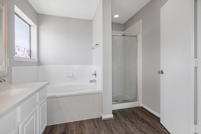8111 Sanders Forest Ct, Humble, TX 77338 - full bath with a stall shower, wood finished floors, vanity, a garden tub, and baseboards