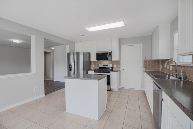 8111 Sanders Forest Ct, Humble, TX 77338 - kitchen with stainless steel appliances, a sink, decorative backsplash, dark countertops, and white cabinetry