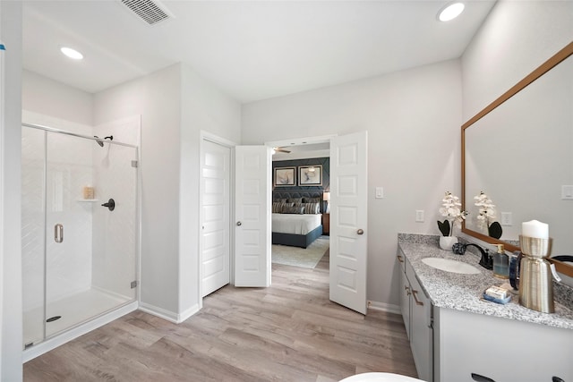 701 Barton Place Dr, Cleveland, TX 77327 - full bath with wood finished floors, vanity, a stall shower, baseboards, and recessed lighting