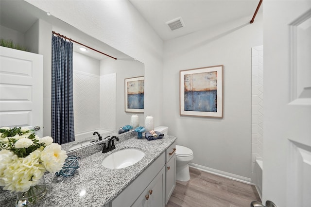 701 Barton Place Dr, Cleveland, TX 77327 - bathroom featuring wood finished floors, baseboards, toilet, vanity, and shower / bathtub combination with curtain