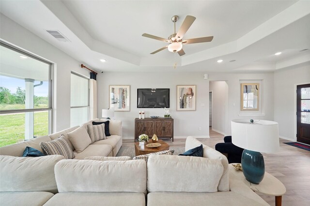 701 Barton Place Dr, Cleveland, TX 77327 - living room with a raised ceiling, light wood-style flooring, healthy amount of natural light, and recessed lighting