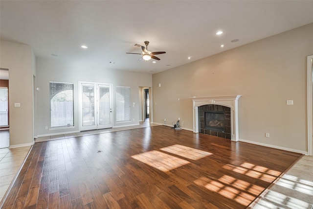 18618 Arlan Lake Dr, Spring, TX 77388 - unfurnished living room with ceiling fan, a tiled fireplace, wood finished floors, baseboards, and recessed lighting