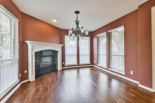 18618 Arlan Lake Dr, Spring, TX 77388 - unfurnished living room with baseboards, a chandelier, dark wood finished floors, and a tile fireplace