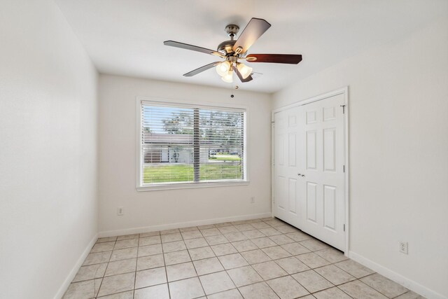 6038 Woodbrook Ln, Houston, TX 77008 - unfurnished bedroom with light tile patterned flooring, baseboards, a ceiling fan, and a closet