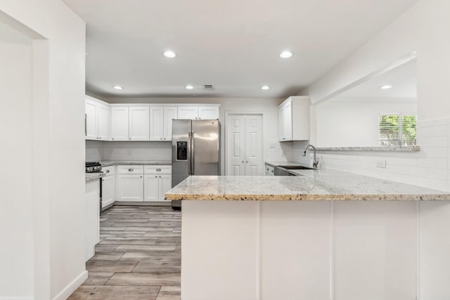 6038 Woodbrook Ln, Houston, TX 77008 - kitchen with stainless steel fridge, a peninsula, backsplash, a sink, and light stone counters