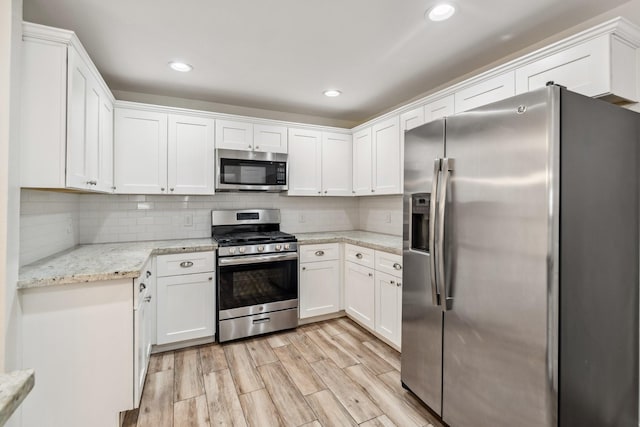 6038 Woodbrook Ln, Houston, TX 77008 - kitchen with stainless steel appliances, white cabinets, backsplash, light wood-type flooring, and recessed lighting