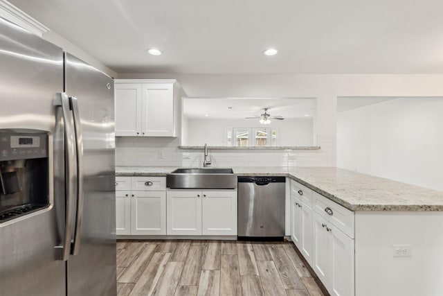 6038 Woodbrook Ln, Houston, TX 77008 - kitchen featuring appliances with stainless steel finishes, a sink, light wood-type flooring, ceiling fan, and white cabinets