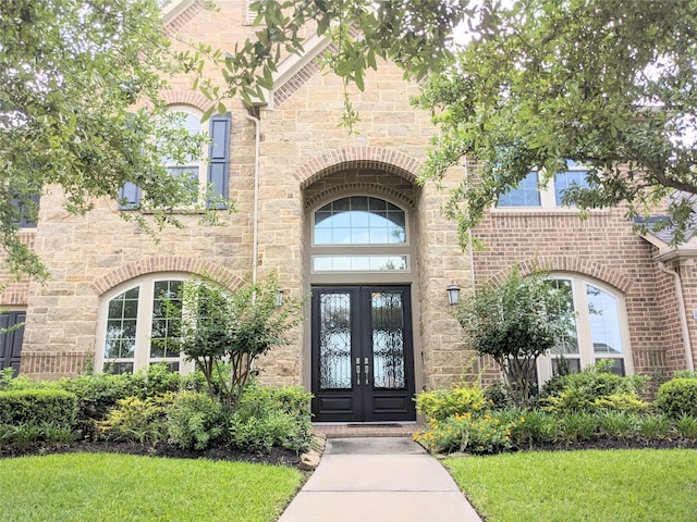 2530 Sparrow Crest Dr, Katy, TX 77494 - entrance to property with french doors, stone siding, and a lawn