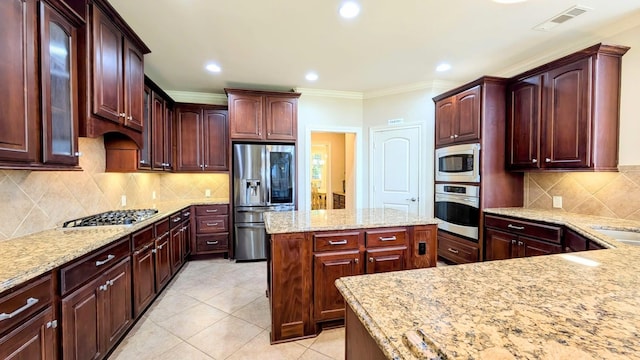 2530 Sparrow Crest Dr, Katy, TX 77494 - kitchen with stainless steel appliances, light stone countertops, decorative backsplash, a center island, and light tile patterned floors