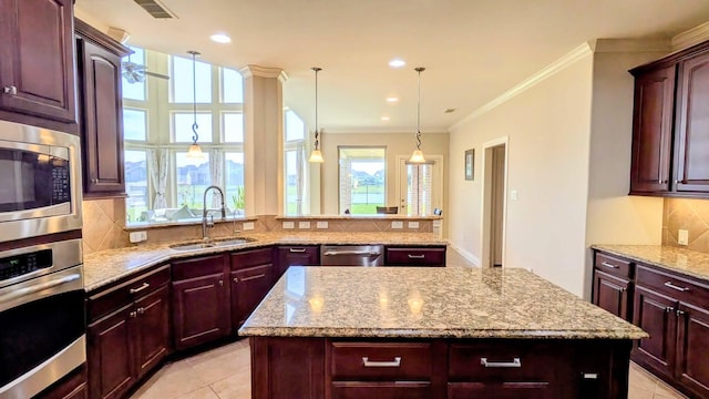 2530 Sparrow Crest Dr, Katy, TX 77494 - kitchen featuring stainless steel appliances, a sink, decorative backsplash, light stone counters, and a center island