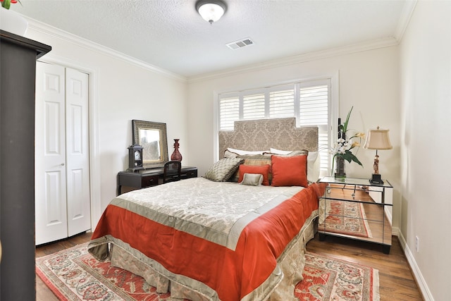 6235 Queenswood Ln, Houston, TX 77008 - bedroom featuring wood finished floors, crown molding, baseboards, a textured ceiling, and a closet