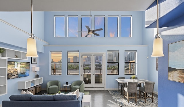 2323 Polk St Unit 302, Houston, TX 77003 - living room featuring baseboards, ceiling fan, a high ceiling, plenty of natural light, and wood finished floors
