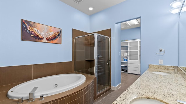2323 Polk St Unit 302, Houston, TX 77003 - full bath with tile patterned floors, a shower stall, a walk in closet, and a jetted tub