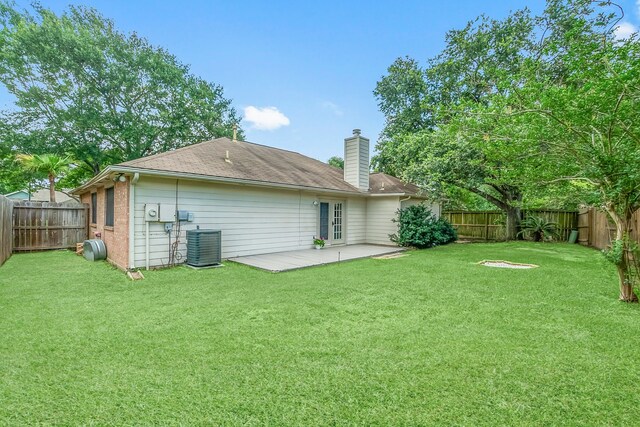 31115 Perlican Dr, Spring, TX 77386 - back of property with a chimney, a patio area, and central AC